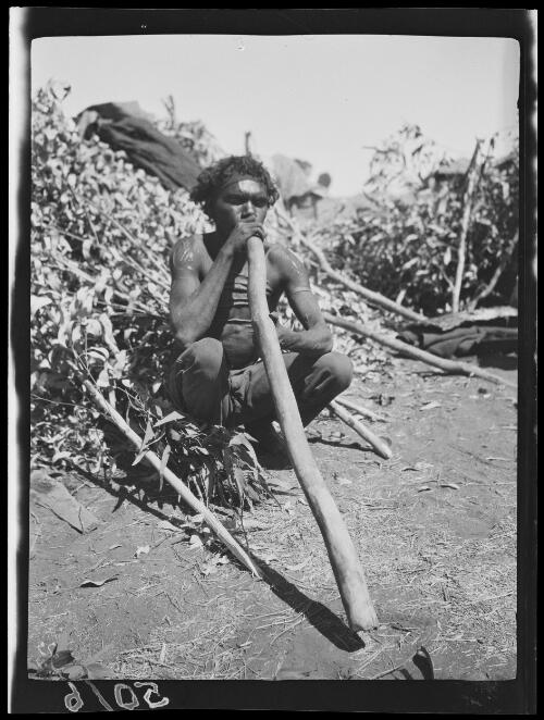 Didgeridoo player with scarring on chest and abdomen and body paint, Wave Hill Station, Northern Territory, 1925 / Michael Terry