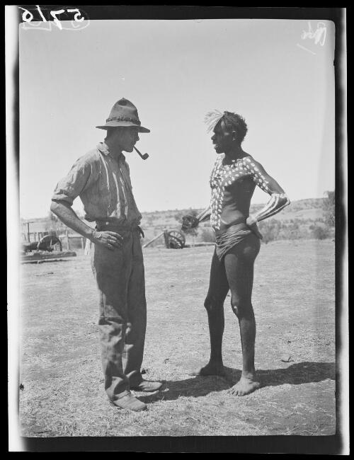 An Aboriginal Australian man wearing feathers and body paint talking with Michael Terry at Wave Hill Station, Northern Territory, approximately 1925 / Michael Terry