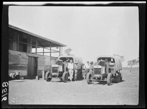 Expedition members standing with their vehicles next to a corrugated iron building, Gordon Downs, Western Australia, approximately 1925 / Michael Terry