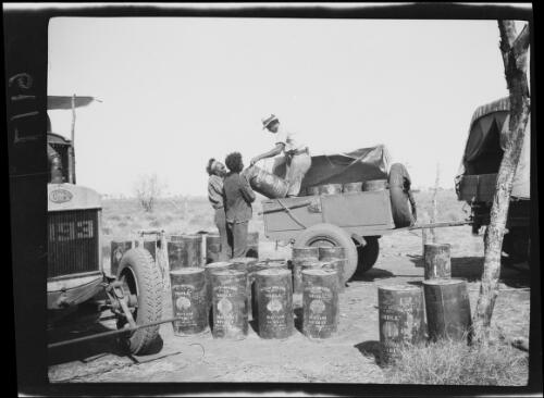 Loading drums of fuel into the expedition trailer, Western Australia, 1925 / Michael Terry