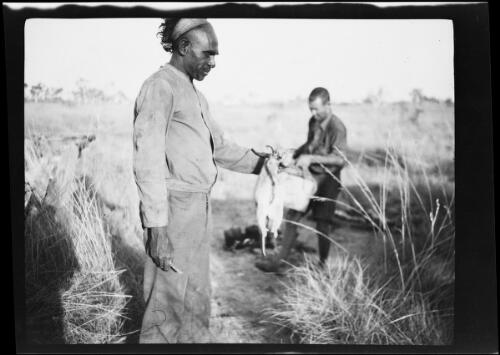 Aboriginal Australian man holding a small marsupial, Western Australia, 1925 / Michael Terry