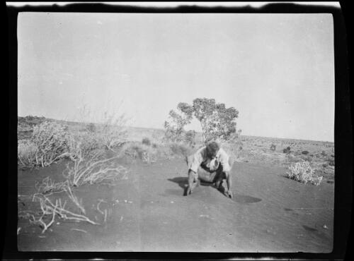 One of the expedition team member examining a sand dune, Western Australia, 1925 / Michael Terry