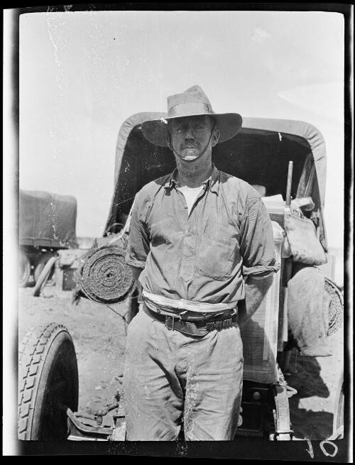 Expedition member Tom Campbell standing with an expedition vehicle, Western Australia, 1928 / Michael Terry