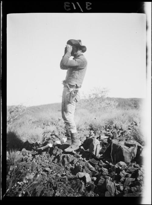 Michael Terry using binoculars, Central Australia, approximately 1930