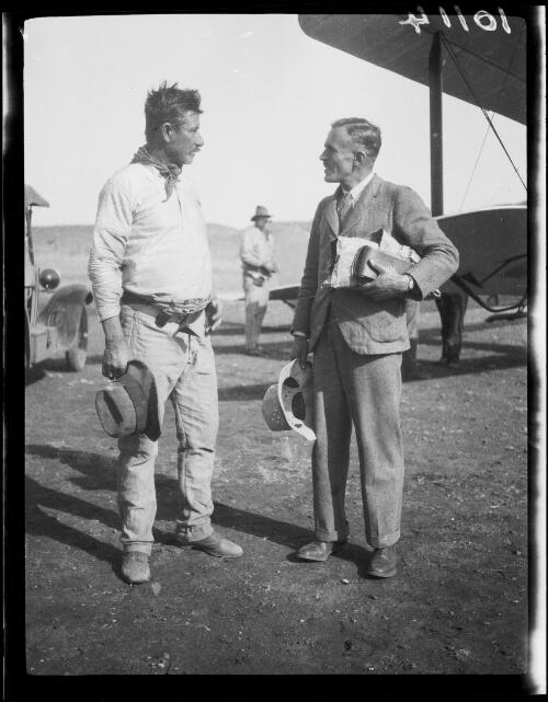Prospector Tom Hanlon and aviator Lester Brain talking between a truck and De Havilland DH50J Atalanta biplane, Central Australia?, approximately 1929 / Michael Terry