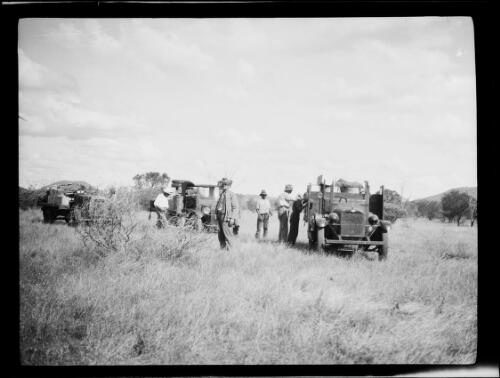 Five expedition members, a Morris Commercial truck and two other trucks in grassland, Central Australia?, approximately 1930 / Michael Terry