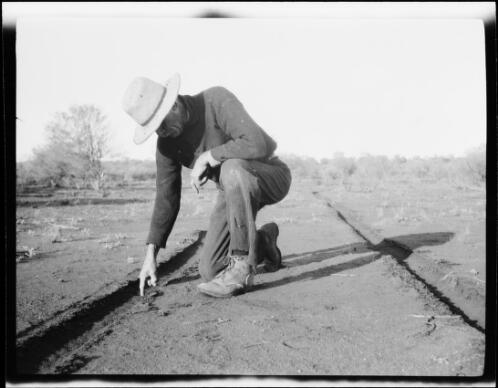 Expedition member Billy Williams measuring the depth of tire tracks, Central Australia?, approximately 1930 / Michael Terry