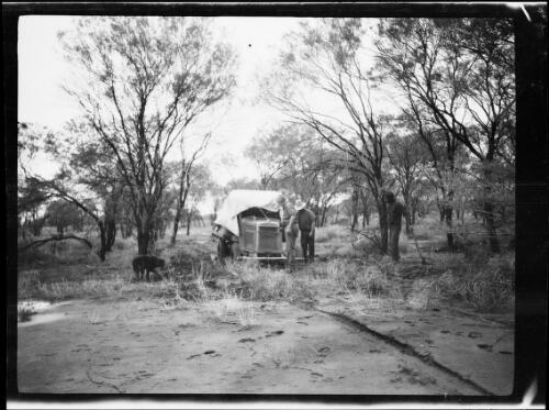 Three expedition members, a Morris Commercial truck and a dog in wooded scrubland, Central Australia?, approximately 1930 / Michael Terry