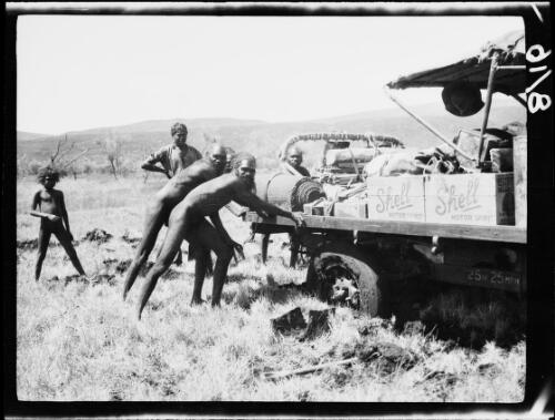 Aboriginal Australians pushing a bogged Morris Commercial truck, Tomkinson Ranges, South Australia, 1930 / Michael Terry