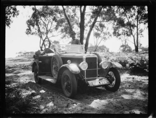 Man standing behind a Morris car on a sandy track, Australia, approximately 1925 / Michael Terry