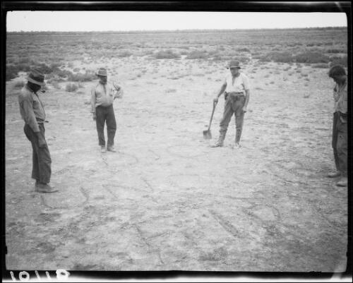 Expedition members standing around Lasseter's message scratched into the surface of Lake Christopher, Western Australia, 1932 / Michael Terry