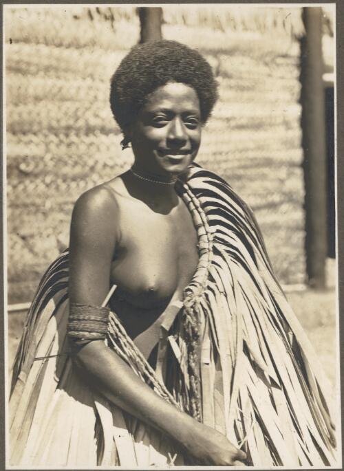 A Boanai beauty, North Coast [wearing a grass skirt over her shoulder] [picture] / Frank Hurley