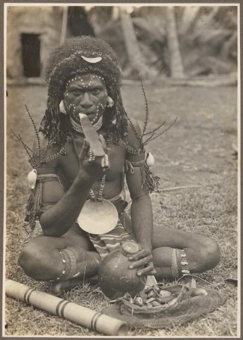 Types from Buna District [man seated, possibly eating betel nut] [picture] / Frank Hurley