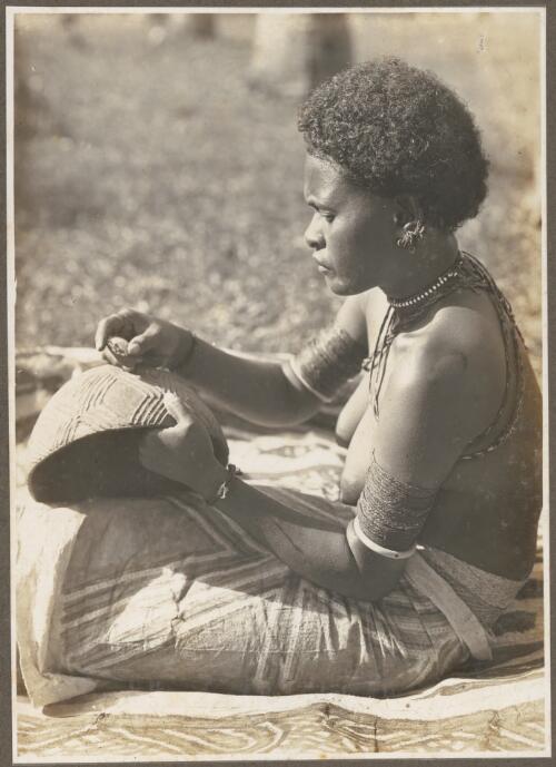 Girls Wanigella [Wanigela] village [seated woman with a pot] [picture] / Frank Hurley