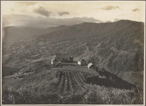 Scenes at Ononge [Looking down to a collection of buildings and a church overlooking a valley] [picture] / Frank Hurley