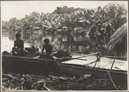 Nipa Palms, Opi River, [two men in a boat on the river edge with palm trees in the background] [picture] / Frank Hurley