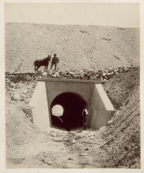 [A man and horse standing on top, and another man by the side of a concrete culvert on the railway line construction site] [picture] / Ryan & Thompson