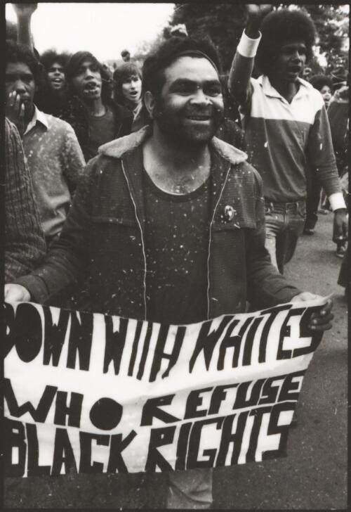 [Unidentified Aboriginal male protestor holding 'Down with whites who refuse black rights' banner at land rights demonstration, Parliament House, Canberra, 30 July 1972, 1] [picture] / Ken Middleton