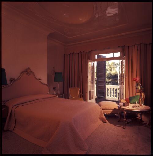 [A bedroom with gold-leaf covered furniture and apricot moire curtains and bedspread beneath a domed ceiling which mirrors the open doors to the balustraded balcony, Sydney, ca. 1971] [transparency] / David Beal