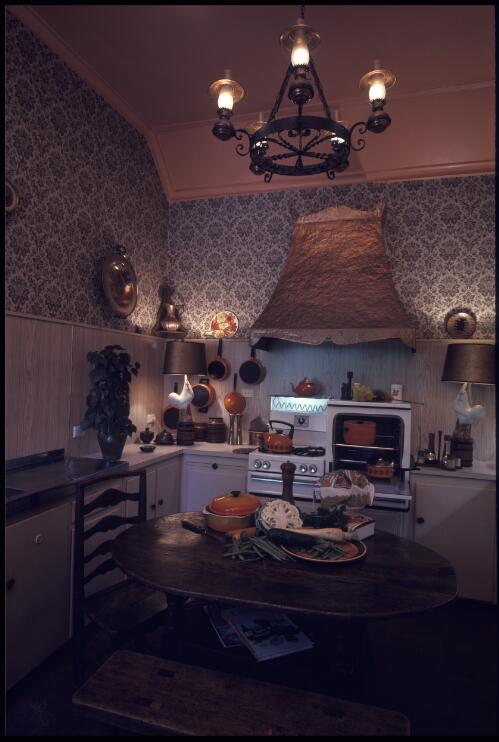 [Kitchen with brown and black damask wallpaper, wooden panelling, oiled furniture and black iron hanging lights, ca. 1971] [transparency] / David Beal