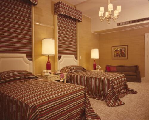 [Bedroom in the Marlene Dietrich Suite at the Australia Hotel with twin beds with horizontal striped bedspreads and matching blinds, ca. 1971] [transparency] / David Beal