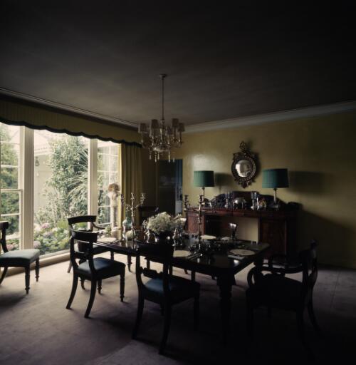 [Dining room with metallic yellow wall and green lampshades and a dark table with open glass doors leading to a garden, ca. 1971] [transparency] / David Beal