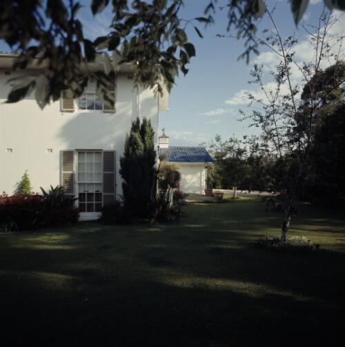 [View of a corner of a two-storeyed white house with cream coloured shuttered windows, ca. 1971] [transparency] / David Beal