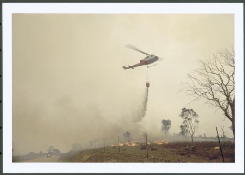 A helicopter dousing a spot fire near the Clearview Road control line, [30 January 2003] [picture] / Jeff Cutting