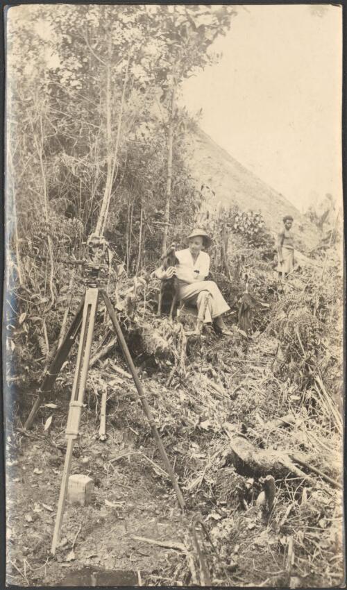 [Iris Spink is seated among the decomposed vegetation in the Edie Creek area holding a dog, Central New Guinea], October 1936 [picture]