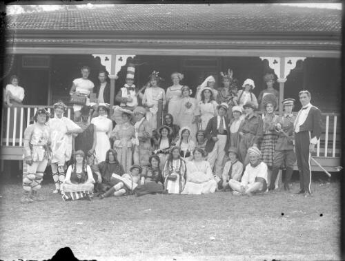 Large group in fancy dress on verandah [picture] / C.C. Fox