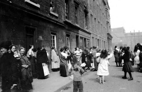 Street scene, children watching Punch and Judy show, Gullane Street, Partick, Glasgow, Scotland, ca. 1918, 2 [picture] / Rex Nan Kivell