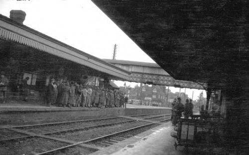 Crowd, including WW1 soldiers, waiting for a train in a station, probably Brockenhurst, Hampshire, United Kingdom [picture] / Rex Nan Kivell