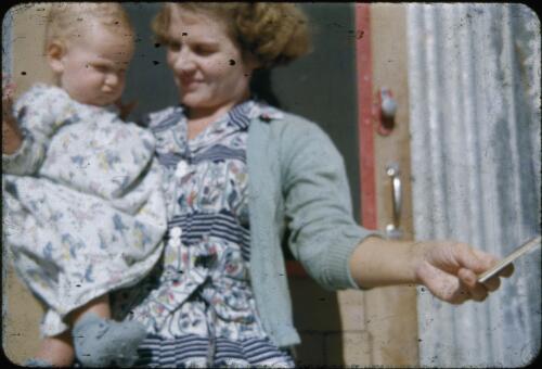 Barbara Lindsay and her baby girl Margaret, at Planet outstation, Arrabury, Queensland,1960s [transparency] / Les McKay