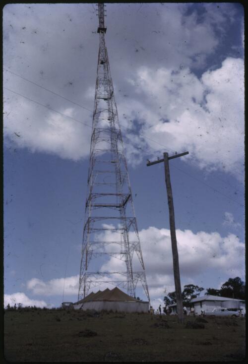 Transmission tower, Reverend Les McKay's Burke & Wills Patrol Land Rover parked beside a marquee at the Royal Flying Doctor Service base, Charters Towers, Queensland, ca. 1965 [transparency] / Les McKay