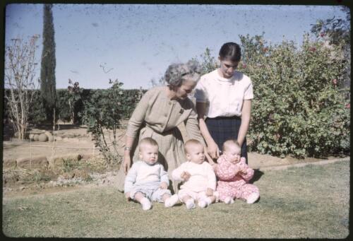 Mary Absolom, another woman and three babies posing in a garden, Davenport Downs, Queensland, 1965 [transparency] / Les McKay