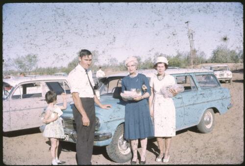 Two women, a man and a child beside a blue EH holden station wagon at the Australian Inland Mission McKinlay Rally, McKinlay, Queensland 1965 [transparency] / Les McKay