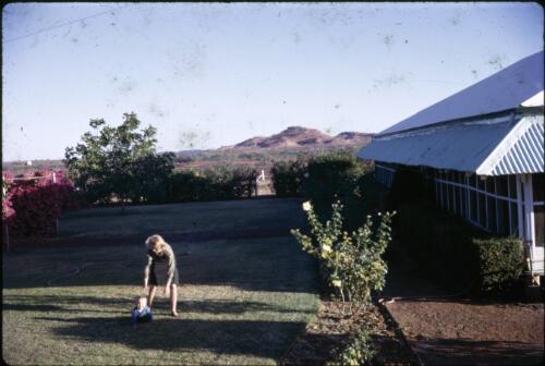 Woman and child on lawn in front of Dagworth Station homestead near Winton, Queensland, ca. 1966 [transparency] / Les McKay