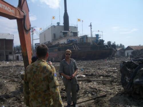 [Australian Defence Force personnel survey the damage caused by the Boxing Day tsunami in Banda Aceh, Indonesia, 10 February 2005, in front of a large barge which has been washed inland] [picture] / AusAID ; photographer, Dan Hunt