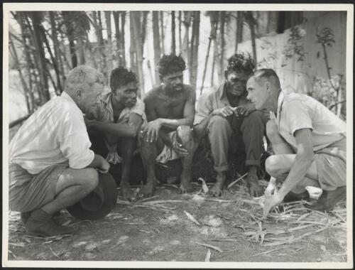 [Bill Harney (left) and Reverend Ellison, mission leader at Goulburn Island, questioning three Aboriginal men who were witnesses to a tribal killing, Goulburn Island, ca. 1940s] [picture]