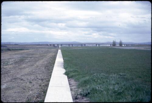 Standing on the south side wall of the lake, Central Basin, looking towards Kings Avenue Bridge (one span only completed), Canberra, ca. 1963 [picture] / Glenys Ferguson