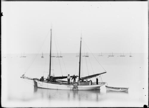 Three men standing in pearling lugger on water, Palmerston [i.e. Darwin], ca. 1890 [picture] / Florenz Bleeser