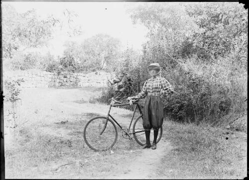 A woman standing on a bush track with a bicycle, Palmerston [i.e. Darwin], ca. 1890 [picture] / Florenz Bleeser