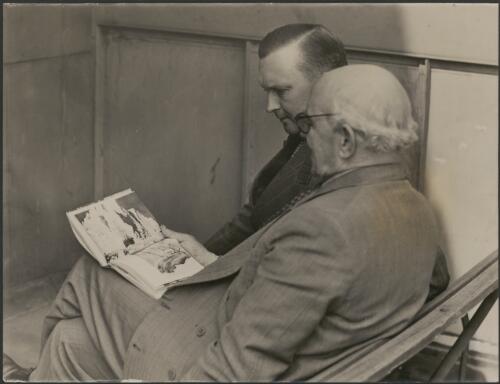 Captain Frank Hurley with the president of the Australian Book Society, Mr. J. Tickell looking at "Shackleton's Argonauts" [picture]