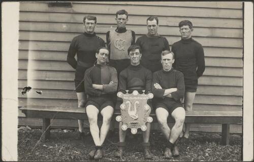 Group portrait of seven cyclists holding the Victorian Cyclists Inter-Club Challenge Shield, Victoria, ca. 1920s [picture]