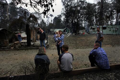 Residents of Tarnpirr Road gather amidst the burnt out ruins after the bushfire, Narbethong, Victoria, 8 February 2009 [picture] / Justin McManus