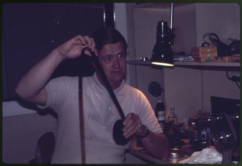 Stephen Fleay holding a 16 mm film in the editing area of CBN 8 television studio, Orange, New South Wales, 1970 [transparency] / Melvyn Pocknall