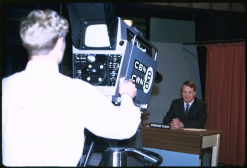 Newsreader Stephen Fleay and cameraman David Payne filming a news segment at the CBN 8 and CWN 6 television studios, Orange, New South Wales, 1968 [transparency] / Melvyn Pocknall