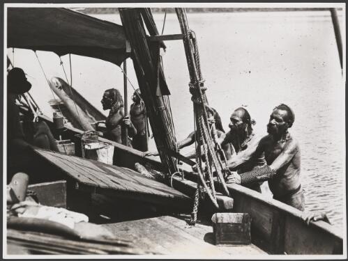 Five Papuan men standing alongside a boat, Papua New Guinea, ca. 1920s [picture] / Frank Hurley
