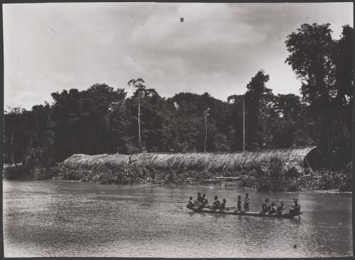 Kiwai men and children in a canoe in front of a communal longhouse on the Bamu River, Papua New Guinea, 1921? [picture] / Frank Hurley