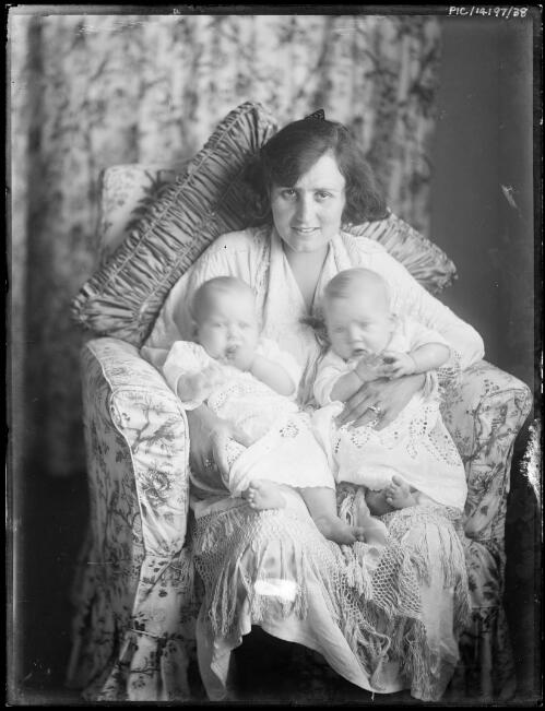Portrait of Antoinette Hurley holding her twin daughters, Toni (right) and Adelie (left), in a floral chair, 1919 [picture] / Frank Hurley